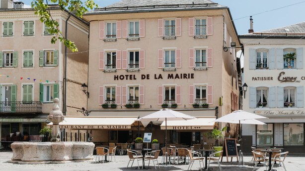 Un hôtel doté d’une terrasse et d’une fontaine.