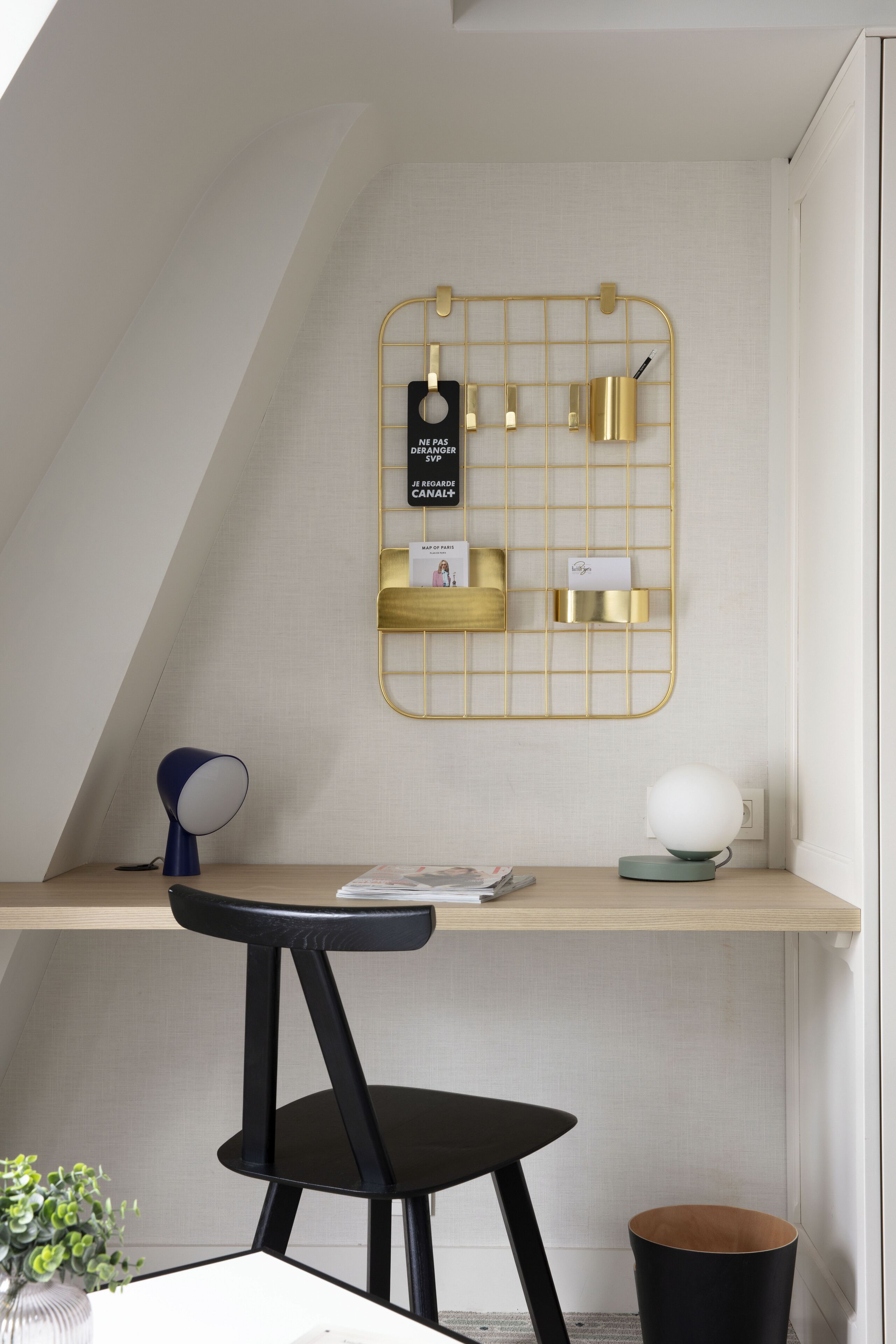 A modern workspace with a desk, chair, and wall-mounted storage.