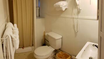 A small bathroom with a toilet, a sink, and a shower curtain.