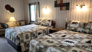 Habitación de hotel con dos camas, un sofá, una lámpara y una ventana.