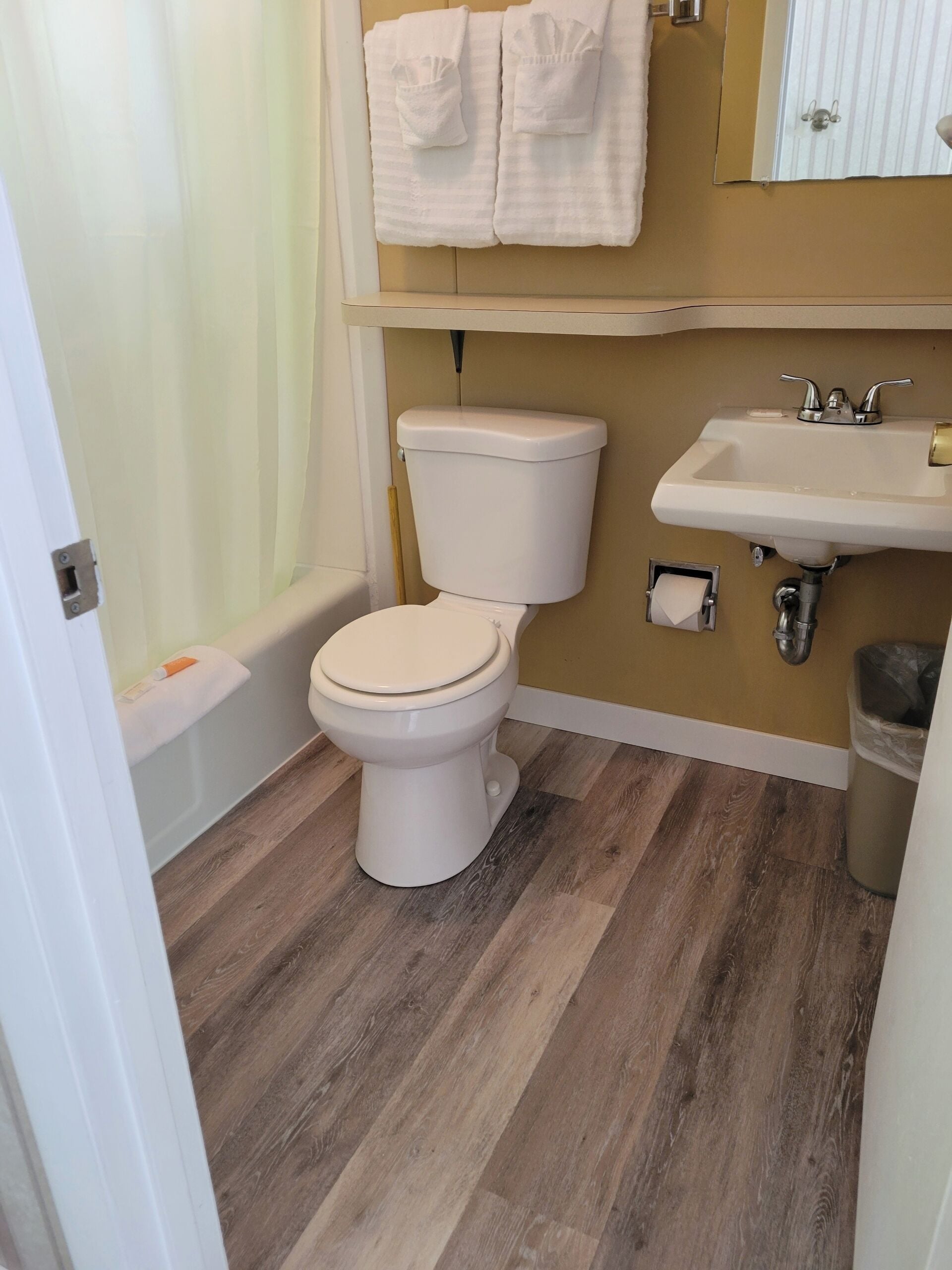 A bathroom with a toilet, sink, and shower curtain.