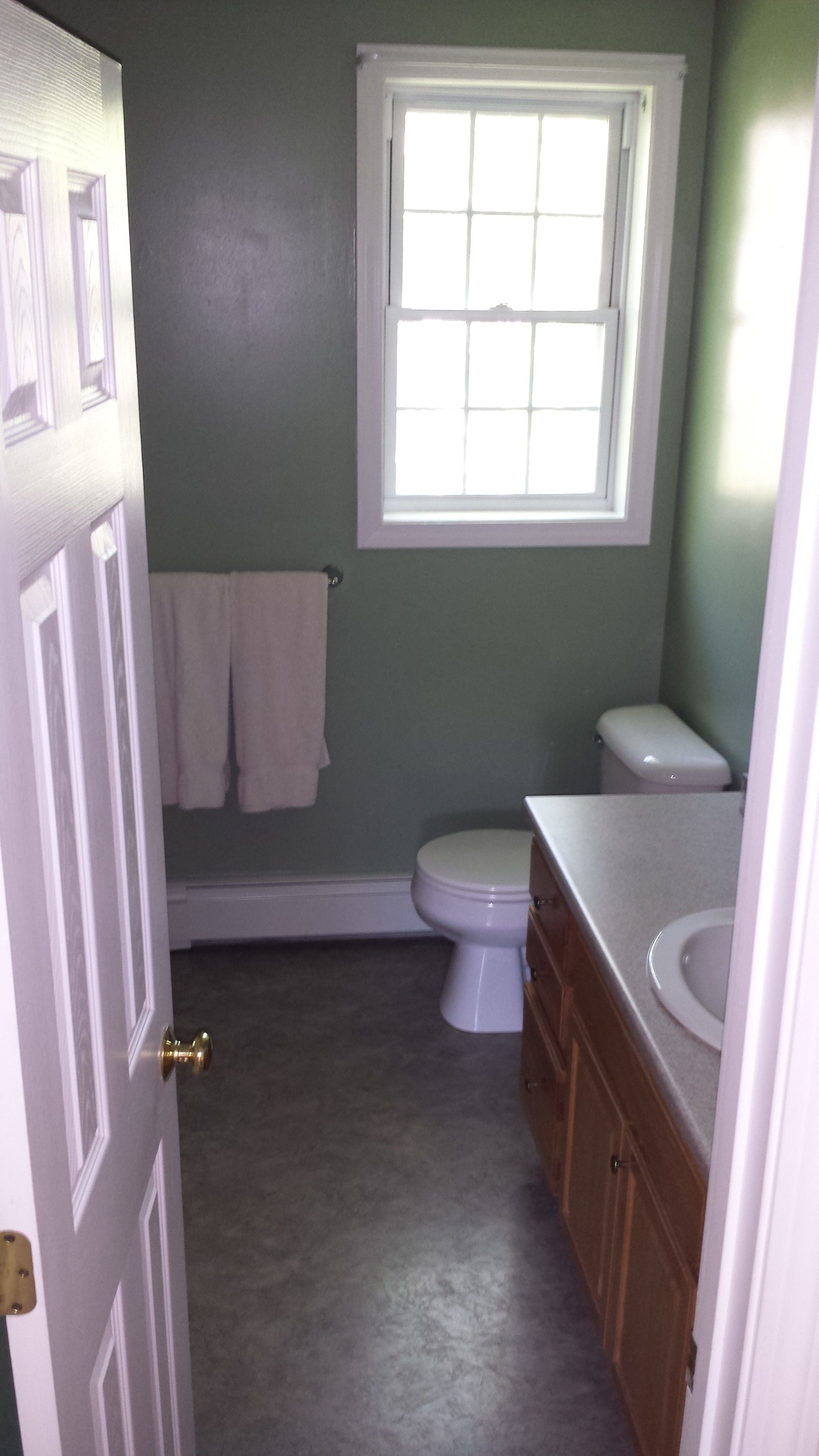 Un baño con inodoro, lavamanos y ventana.