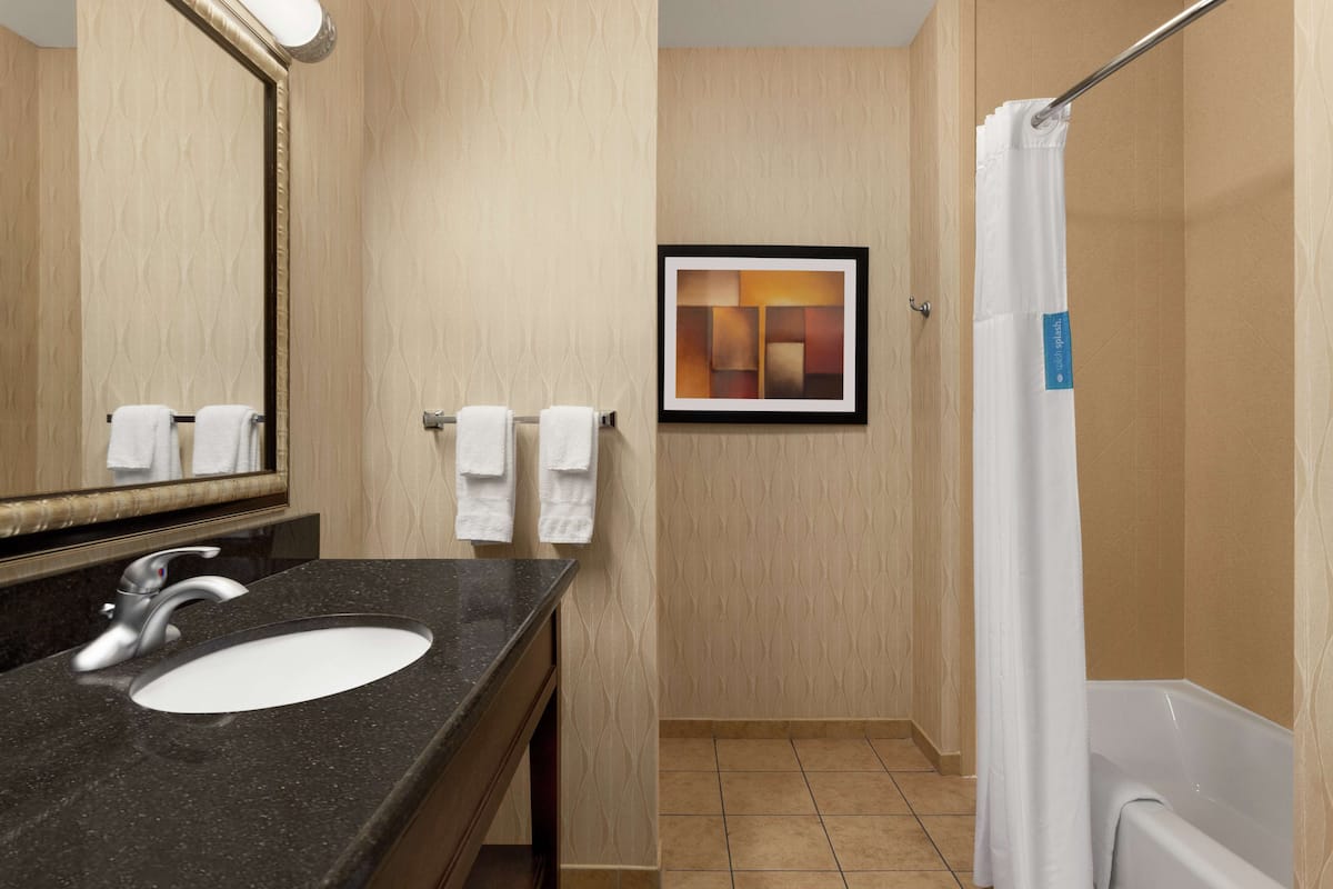 two queens | bathroom | bathtub, hair dryer, bathrobes, towels