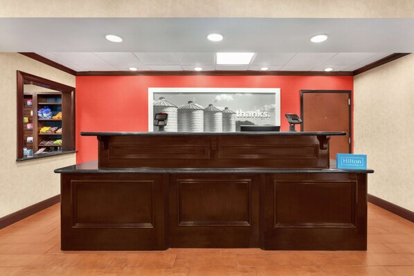 A reception desk with a red wall backdrop, a "thanks" sign, and a "Hilton Honors" sign.