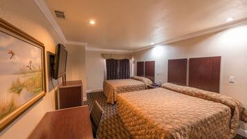 A hotel room with two beds, a desk, a TV, and a painting on the wall.