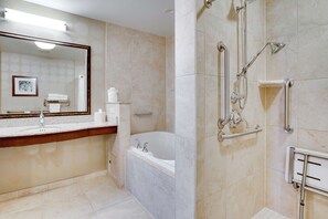 A modern bathroom with a large mirror, a bathtub, and a shower area with grab bars. - Hilton Garden Inn Milwaukee Airport (Milwaukee)