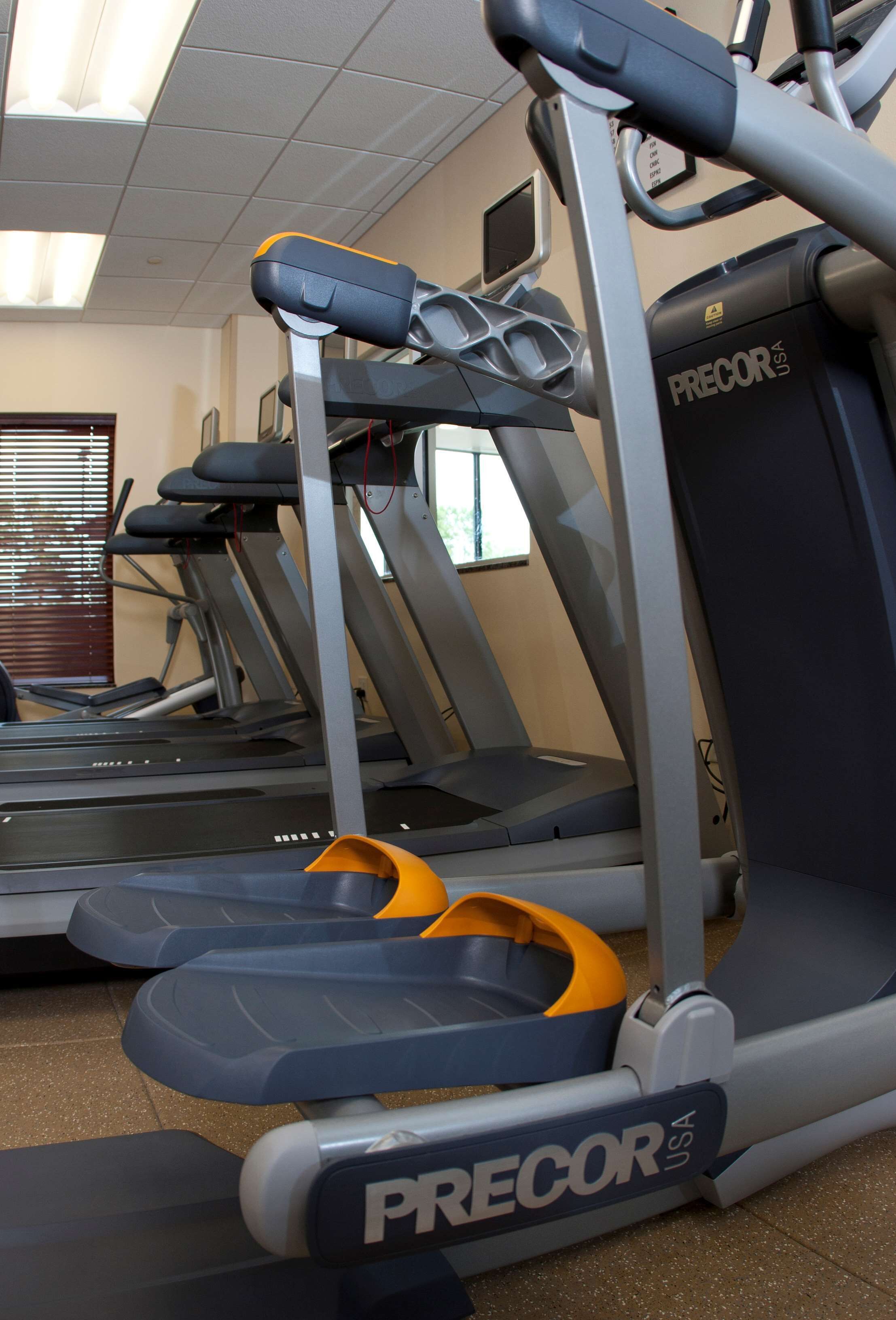A gym with treadmills and a stationary bike, equipped with foot pedals.