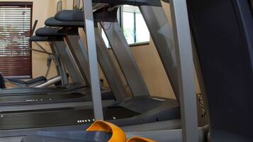 A gym with treadmills and a stationary bike, equipped with foot pedals.