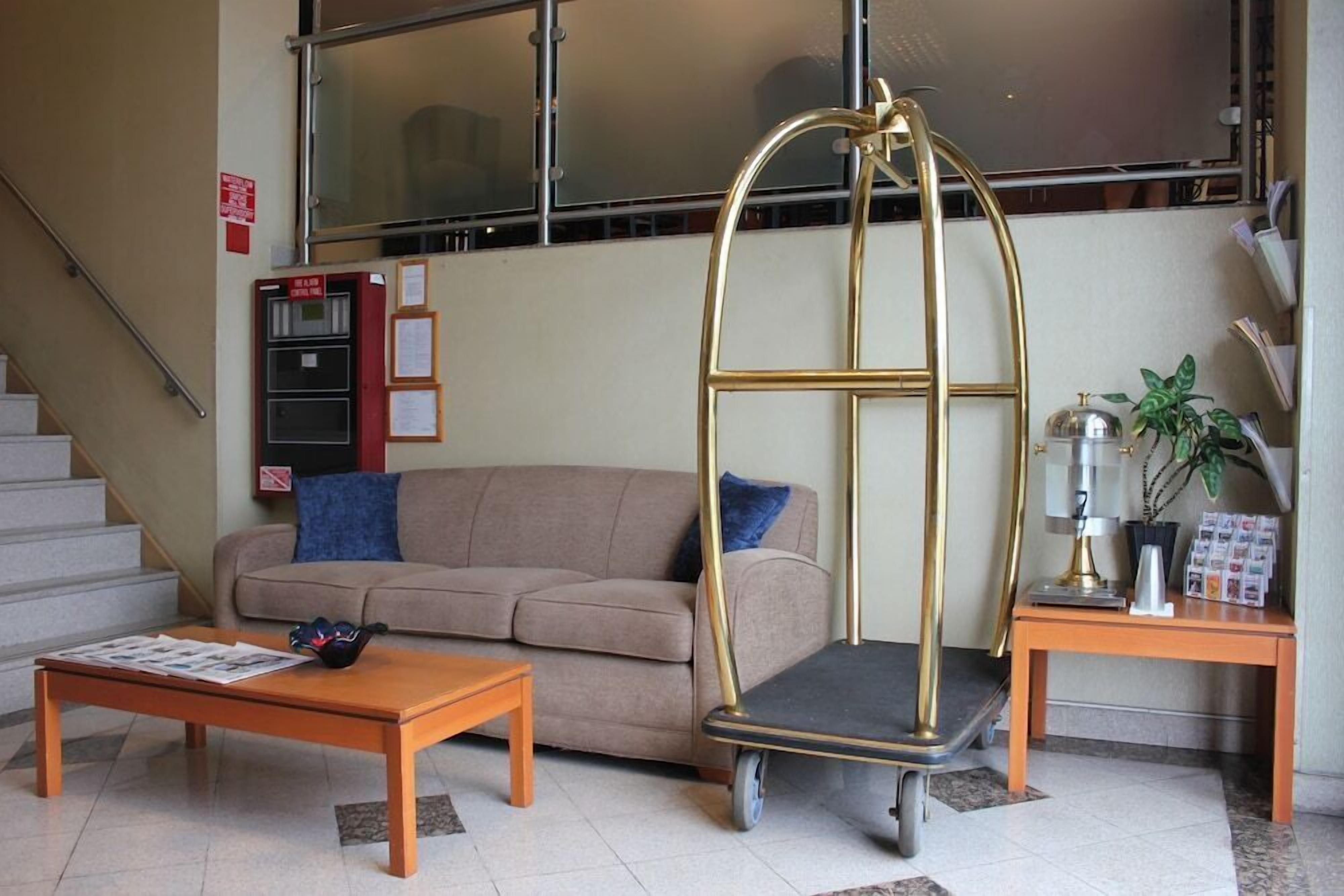 Un soggiorno con divano, tavolino e una sedia in metallo dal design originale.