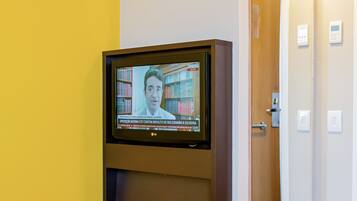 Un televisor fijado en la pared mostrando un programa de noticias.