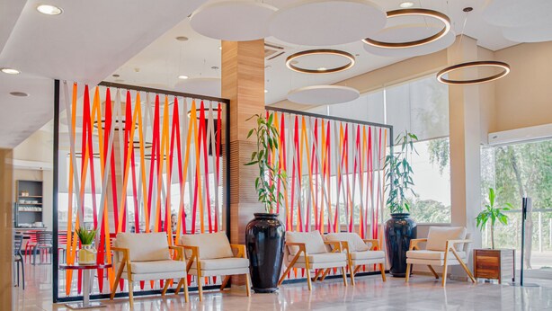 Un hall d’entrée moderne doté d’un espace salon, de grandes fenêtres et de panneaux décoratifs.