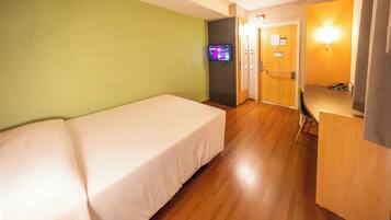 Una habitación de hotel con cama, escritorio y televisión.