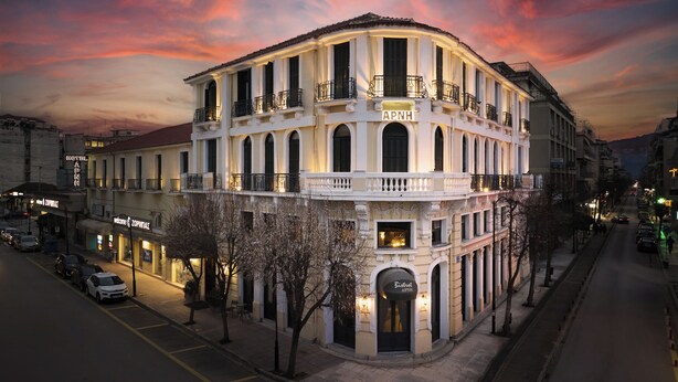 Un hôtel à plusieurs étages, de style architectural classique, doté de balcons et de fenêtres en arc de cercle.