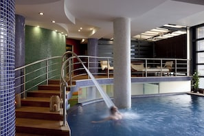 Una piscina techada, una piscina al aire libre de temporada, sombrillas