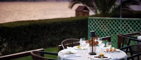 Mesa lista para una comida con vista a un lago y montañas al fondo.