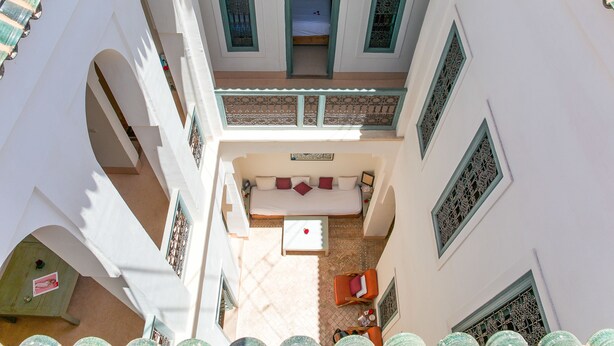 Un patio con una cama, un sofá y una mesa.
