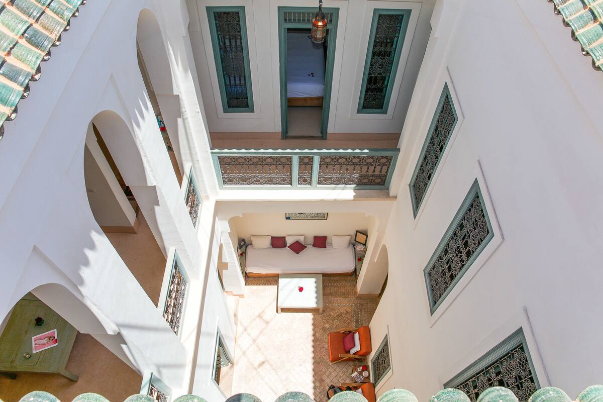 Un patio con una cama, un sofá y una mesa.