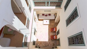 Un patio con una cama, dos sofás y una mesa.