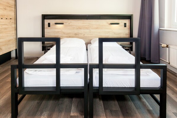 Una cama doble con cabecera de madera en una habitación de hotel.