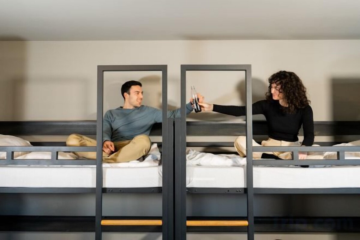 Een stapelbed met twee aparte slaapplekken, elk voorzien van een matras en kussens.