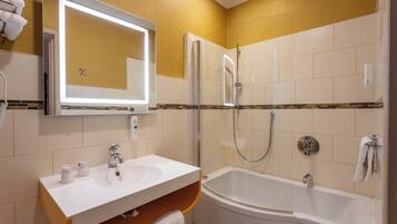 Un baño con lavamanos blanco, espejo y bañera.