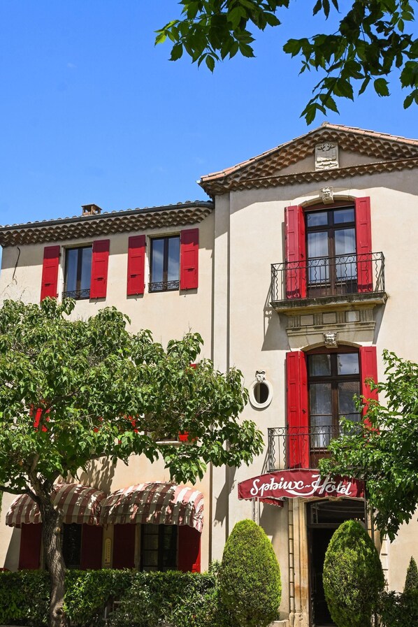 A building with red shutters, a balcony, and a sign reading "Sphinx Hotel". - Citotel Le Sphinx (Montélimar)