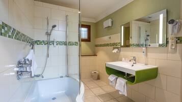 Une salle de bain avec une baignoire, une douche et un lavabo.