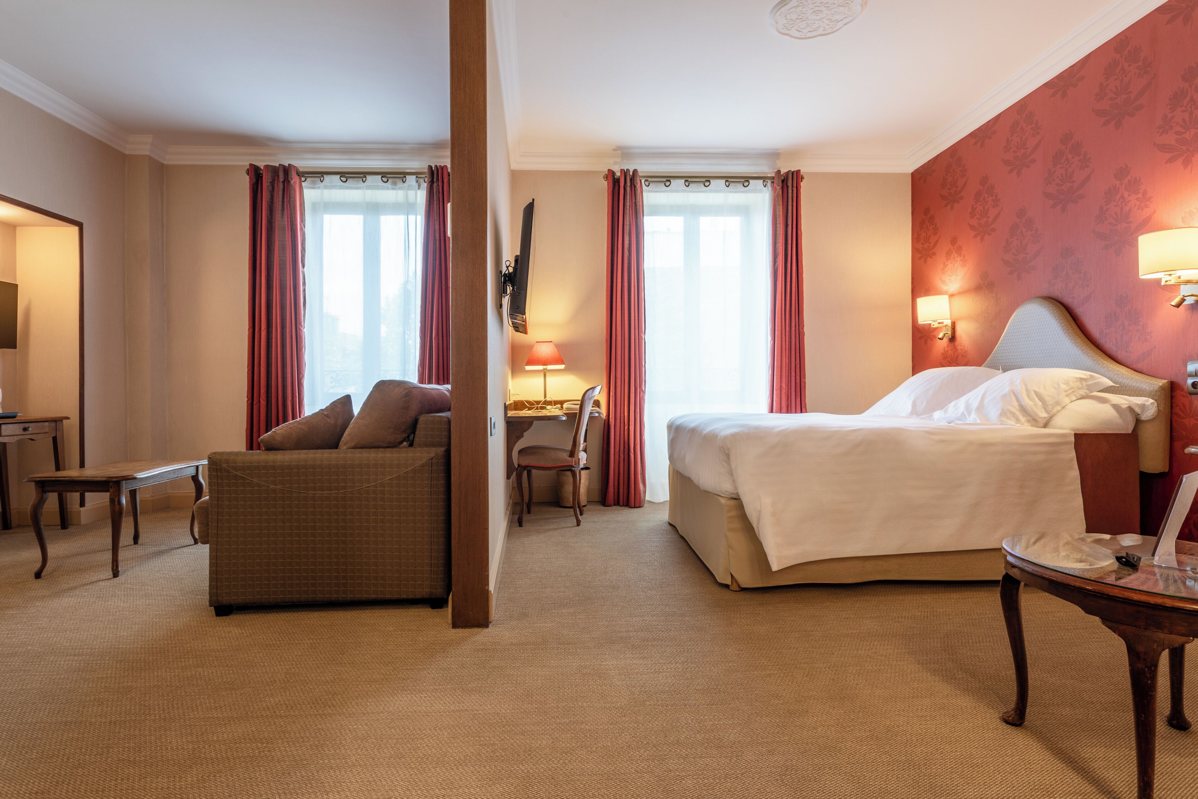 Ett hotellrum med en säng, en soffa, ett skrivbord och en stol.