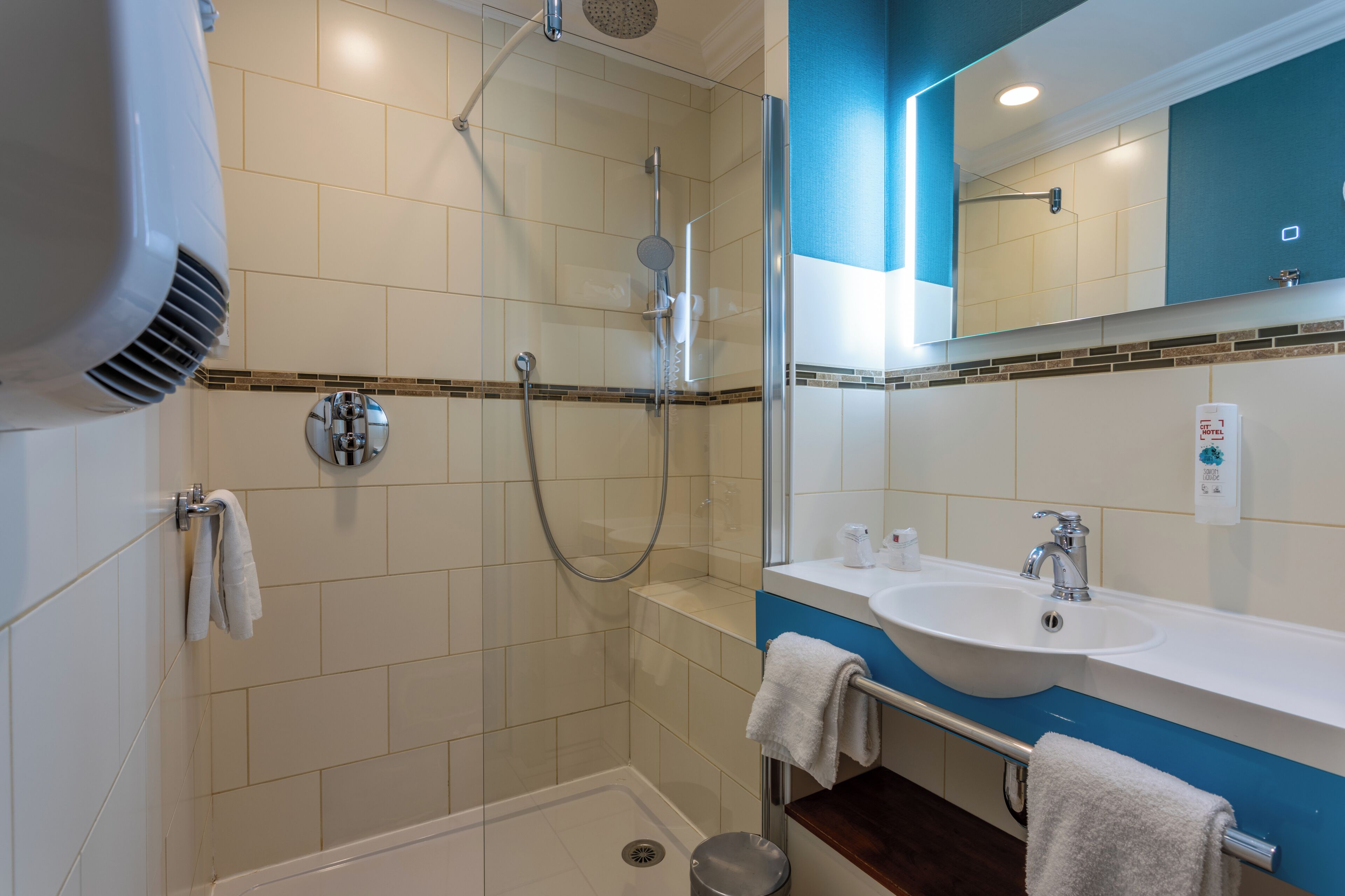 Un bagno moderno con doccia, lavandino e specchio.