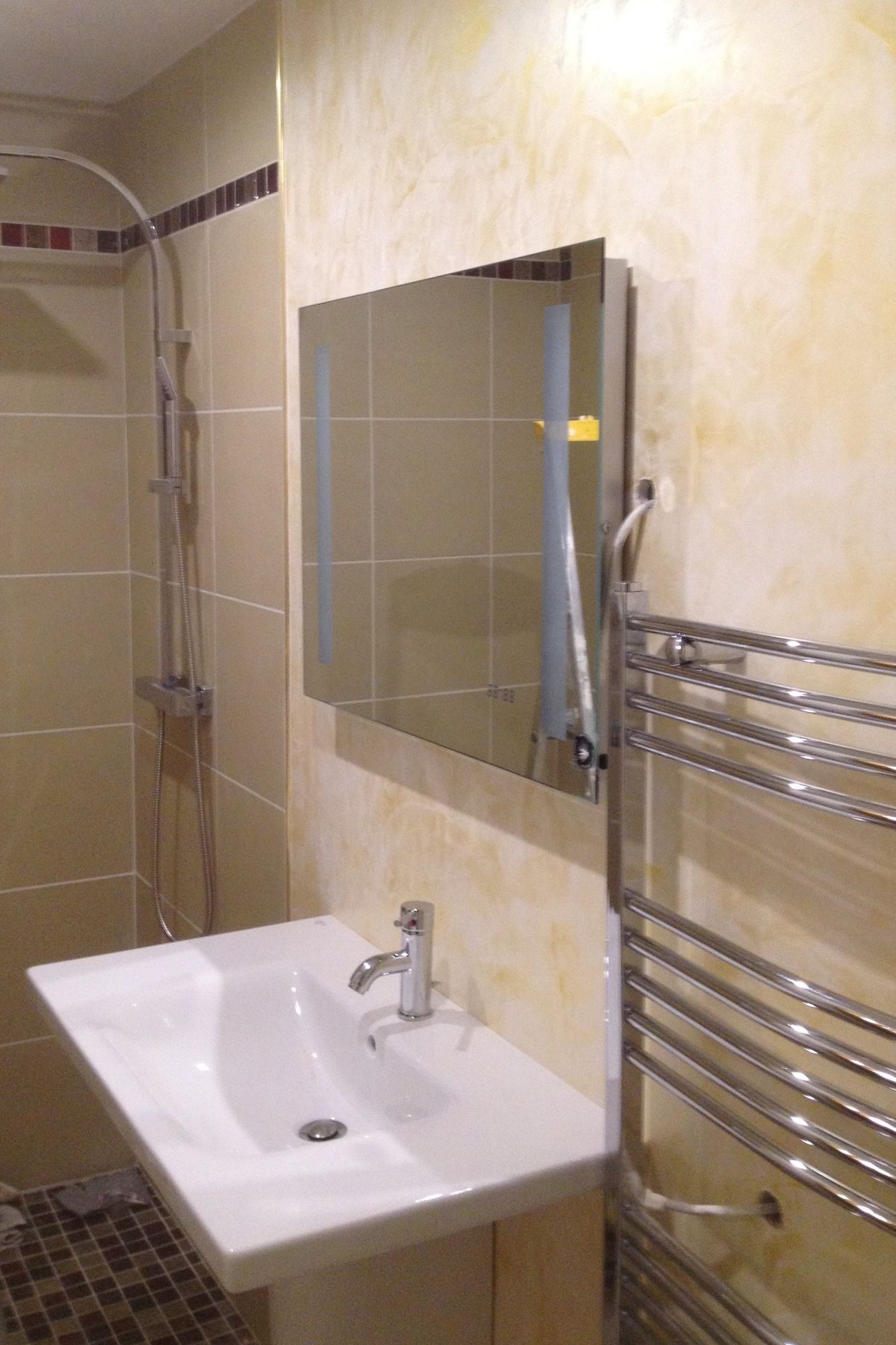 A bathroom with a white sink, a mirror, and a shower.