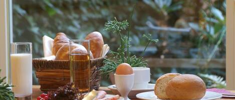 A breakfast table with bread, eggs, and a glass of milk.