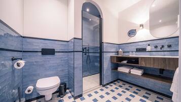 A modern bathroom with a glass-enclosed shower, a white toilet, and a blue-tiled floor.