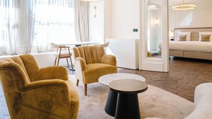 Un salon moderne comprenant un canapé, des fauteuils, une table basse et un coin repas avec une table et des chaises.