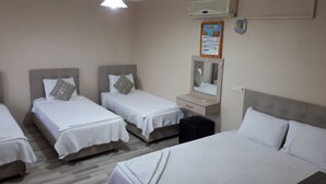 A hotel room with three single beds, a small bedside table with a mirror, and a wall-mounted air conditioner. - Hotel Pamukkale (Denizli)