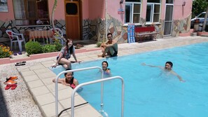 Una piscina con un muro de piedra y un cartel que indica una profundidad de 1,50 metros.