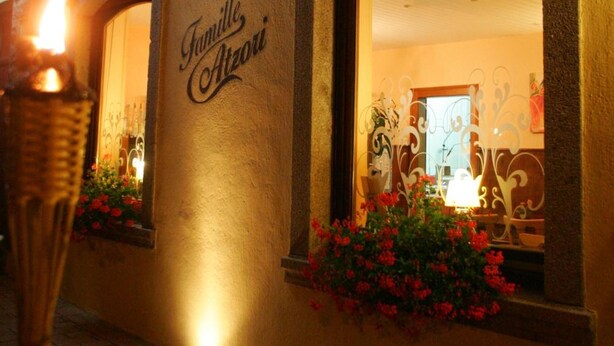A building facade with the sign "La Gatte des Fauces" and "Famille Azori" indicating a family-run establishment.