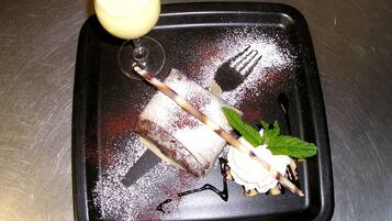 A dessert tray with a chocolate-covered cake, a scoop of ice cream, and a mint garnish.