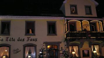 A building with the sign "La Tête des Faux" and a Christmas tree in front.