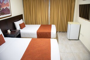 Habitación de hotel con dos camas, una mesita de noche, un refrigerador pequeño y una ventana con cortinas.