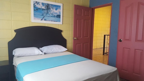 A bed with white and blue bedding, a black headboard, and a framed picture above it.