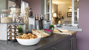 A breakfast buffet setup with jars of spreads, croissants, and a bread basket. - Contact Hôtels Les Pierres Dorées (Amberieux)