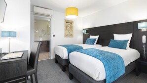 A hotel room with two beds, a desk, a chair, a telephone, and a door leading to a bathroom. - Contact Hôtels Les Pierres Dorées (Amberieux)