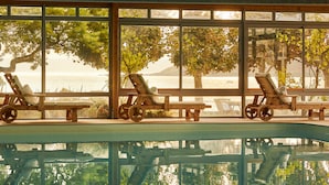 A pool area with lounge chairs and a view of the sea. - Le Grand Hotel des Bains & Spa - Bretagne (Locquirec)