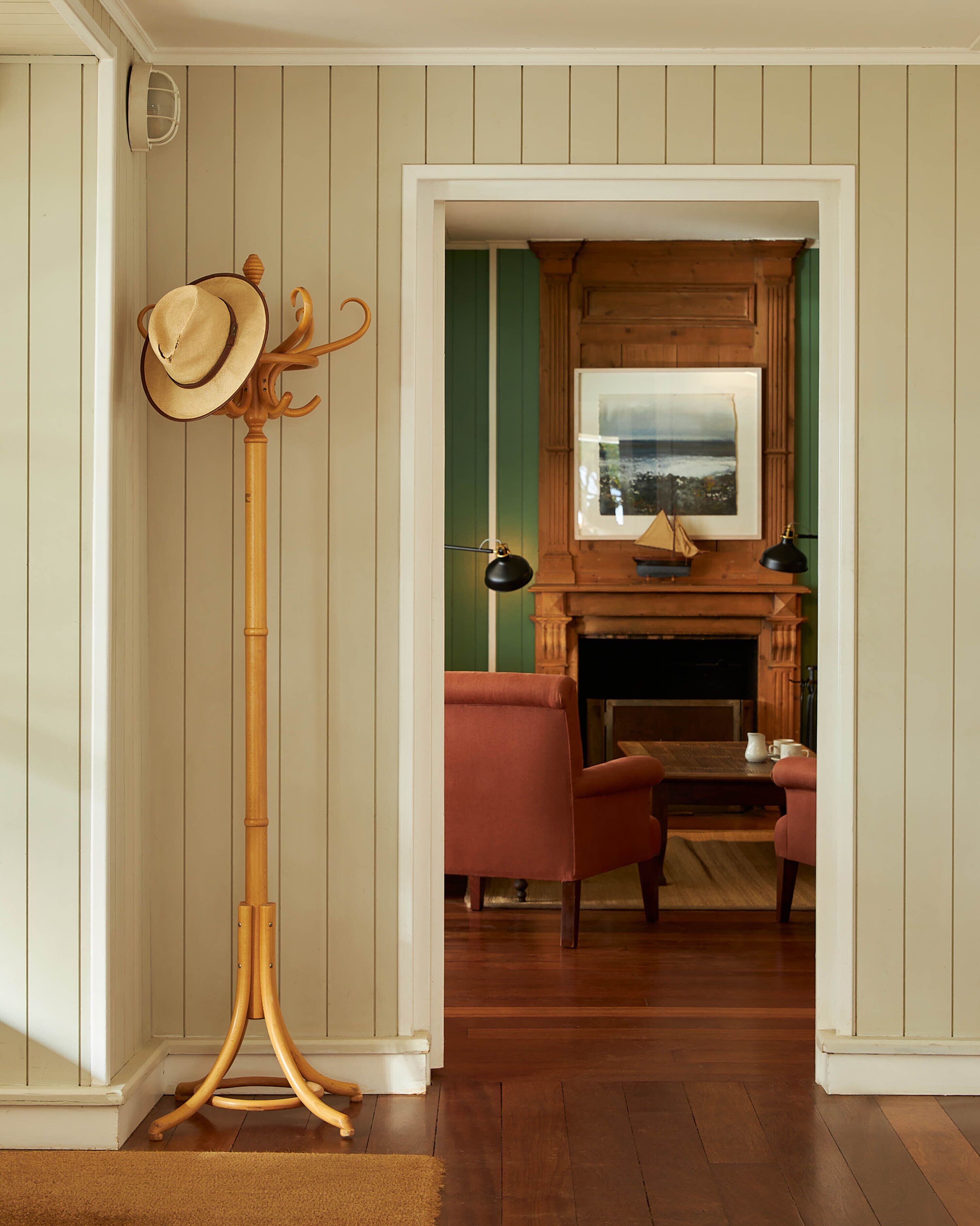 Una habitación con piso de madera, chimenea y una zona de estar con dos sillones.