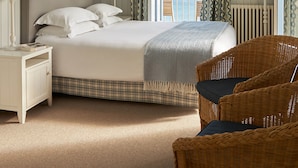 A bedroom with a bed, two bedside tables, a nightstand, a chair, and a view of the sea. - Le Grand Hotel des Bains & Spa - Bretagne (Locquirec)
