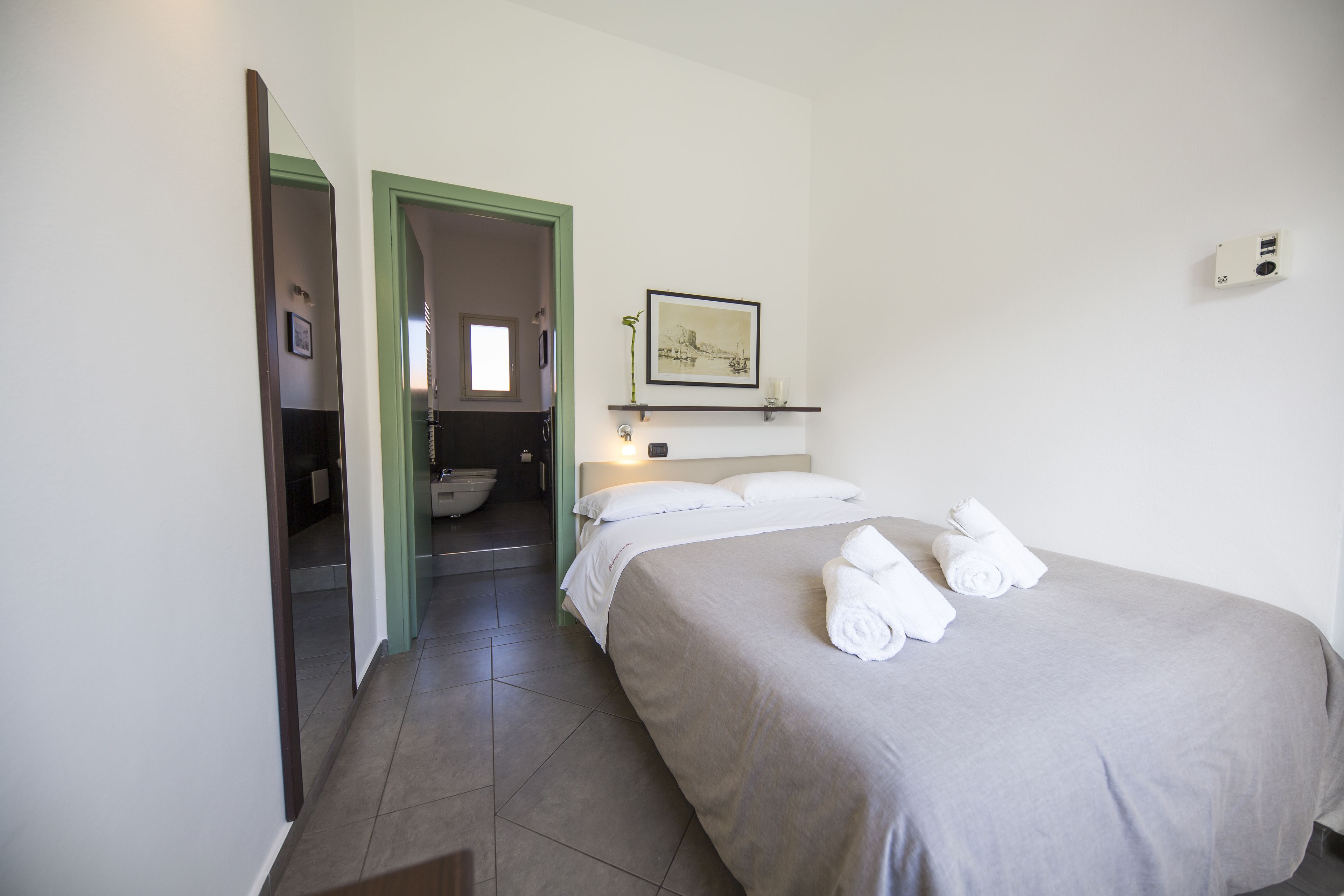 Una habitación de hotel con cama, baño y pasillo.