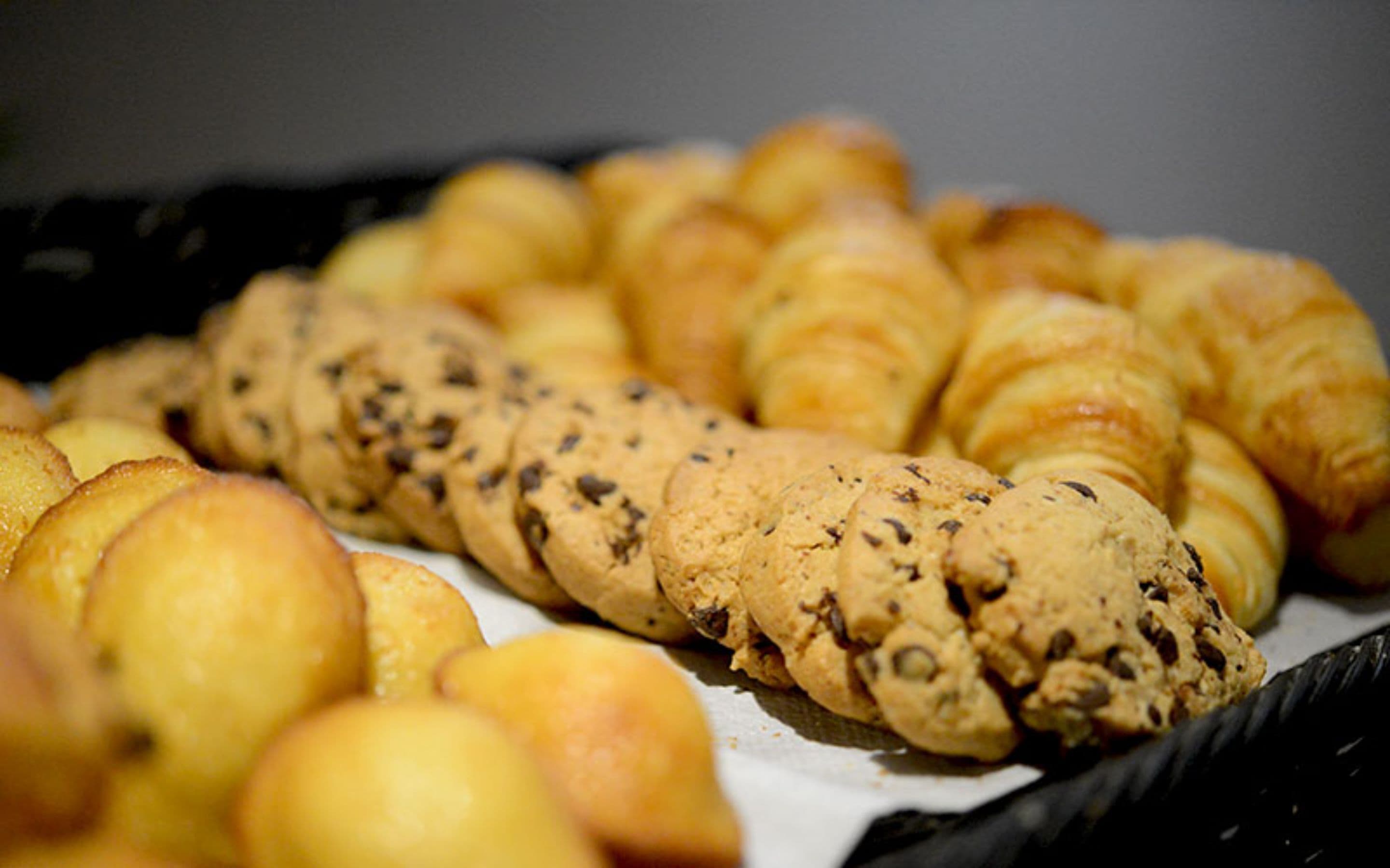A tray of baked goods including croissants and a braided bread.