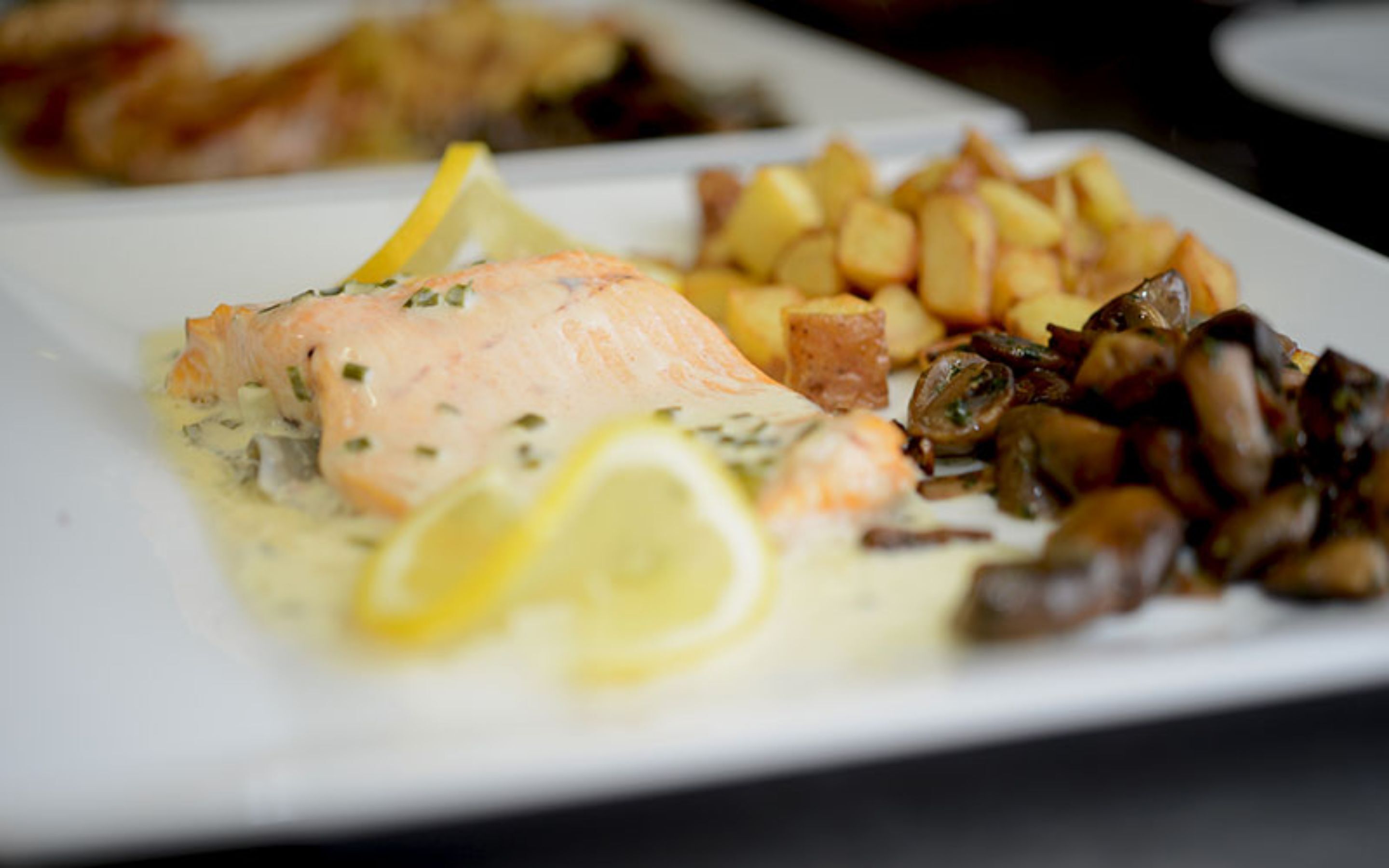 A plate with salmon, potatoes, and mushrooms.