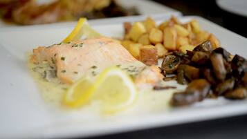 A plate with salmon, potatoes, and mushrooms.
