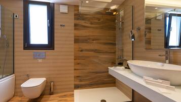 A modern bathroom with a walk-in shower, a toilet, and a large sink.